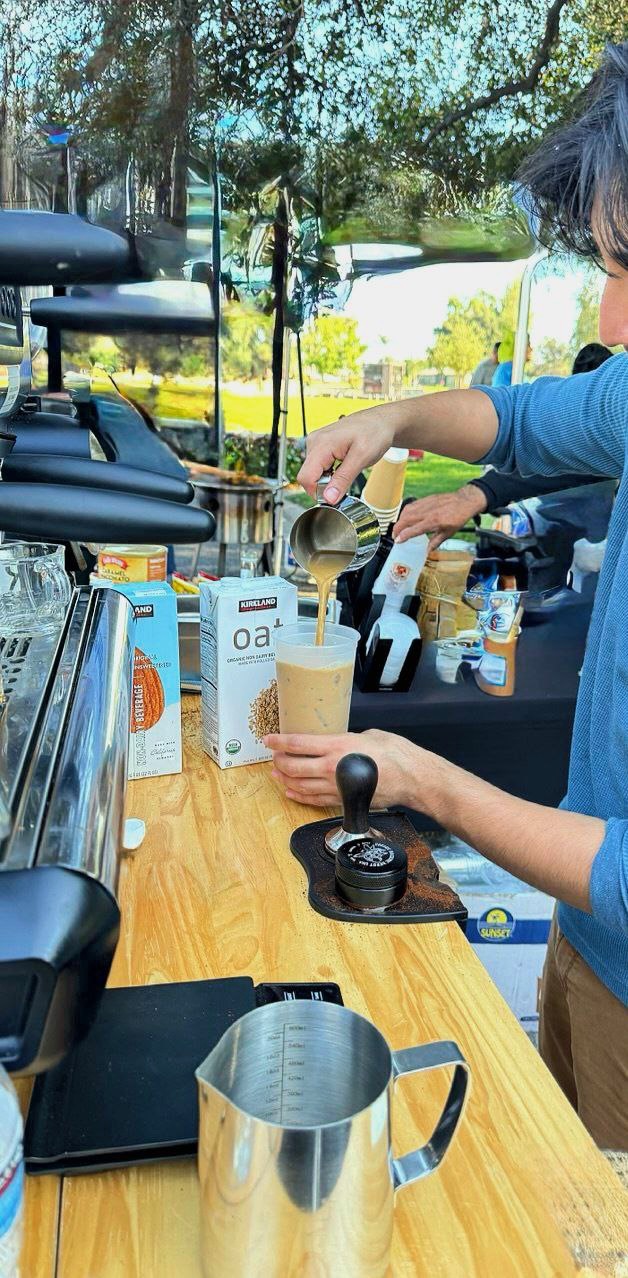 Barista pouring a latte at a catered event